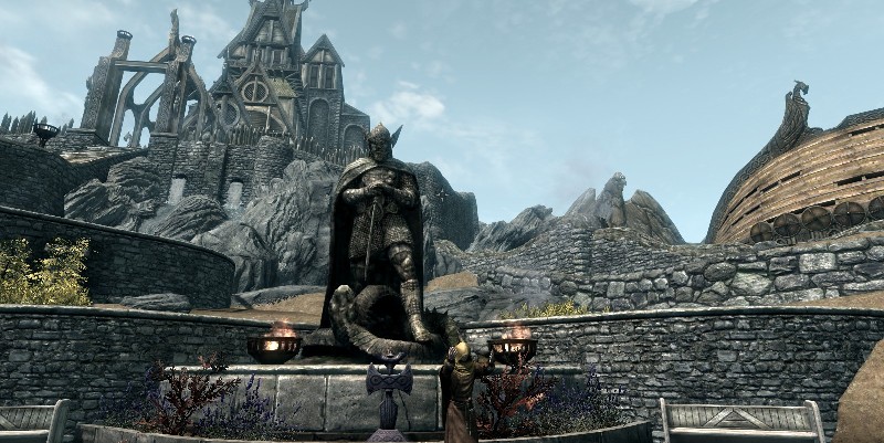 Statue of Talos in Whiterun, with Shrine in front, Dragonsreach to left, giant Eagle in middle, and old Companion's home to right.